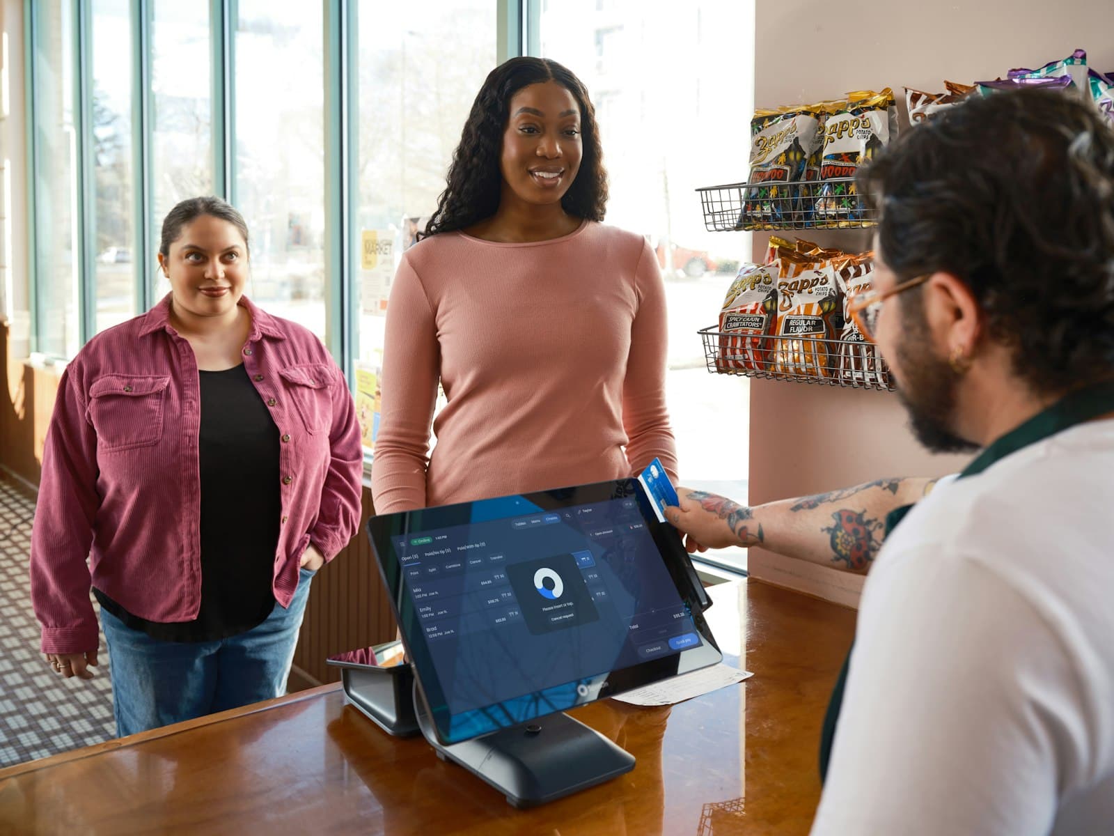 A customer paying at a shop counter point-of-sale system